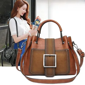 Detail of vintage matte leather handbags with metal buckles and contrast stitching for women