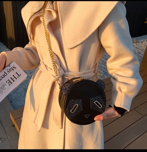 Detail of cute black panda crossbody bag with sequins and gold metal chain strap