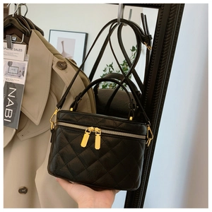 Close-up of black quilted leather bucket bag with gold zippers and stylish handle