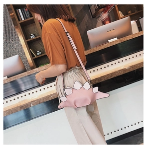 Detailed side view of pink dinosaur-shaped crossbody bag with decorative white plates