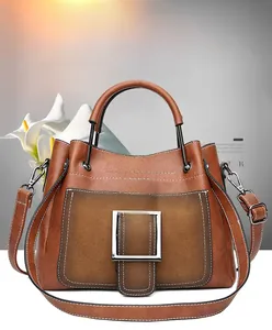 Detail of vintage matte brown leather shoulder bag with silver metal square buckle