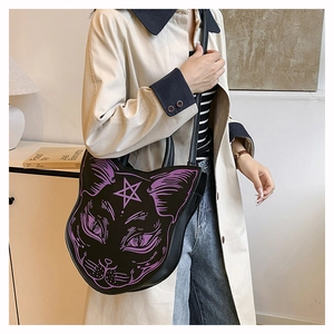 Detail view of black punk cat head cross-body bag with purple accents on a model