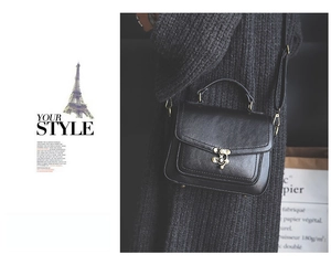 Detail of vintage black PU leather handbag with antique bronze metal lock and stitching