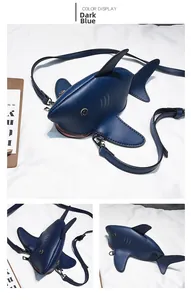 Detail view of deep blue shark-shaped crossbody bag with creative leather fins and metal eyes
