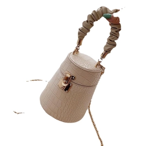 Crocodile pattern bucket bag with cream leather, gold lock, and ruched cloud handle