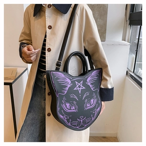 Macro shot of gothic black cat-shaped shoulder bag featuring purple star and face details