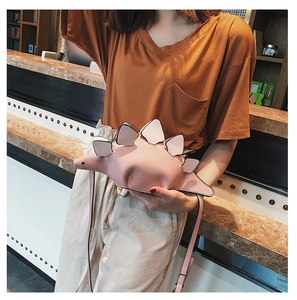 Detail of pink dinosaur dinosaur crossbody bag with distinctive 3D spine plates and strap