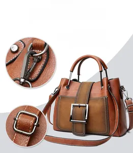 Detail of vintage matte leather handbag featuring contrast stitching and metallic buckles