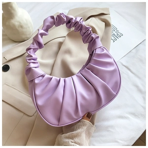 Detail shot of lavender pleated crescent bag with cloud-style handle on neutral background