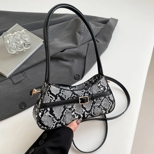 Chic black and white snakeskin square bag with golden buckle and chain strap on blazer