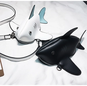 Detail view of creative shark-shaped crossbody bags in black and white matte leather