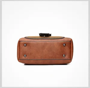Detail of vintage matte leather bag bottom with four silver protective metal feet studs