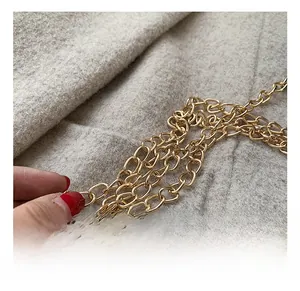 Détail de la bandoulière en chaîne dorée pour petit sac boîte en velours brodé
