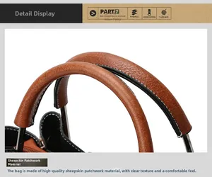 Close-up of caramel brown sheepskin leather handbag handle with white contrast stitching