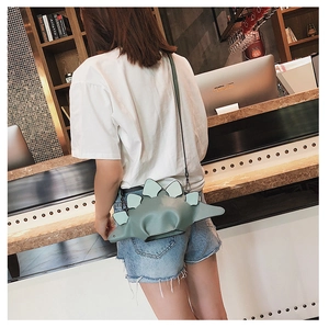 Detail of cute green dinosaur crossbody bag showing side profile and smooth faux leather