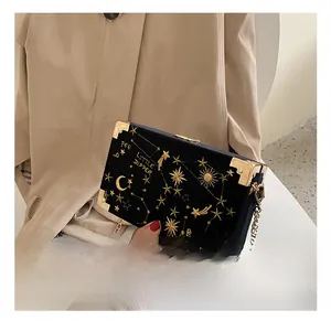 Détail du sac boîte en velours avec broderie d'étoiles dorées et bandoulière chaîne