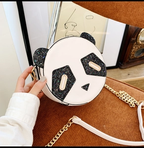 Close-up of a panda-shaped round crossbody bag with shiny black sequins and a gold chain
