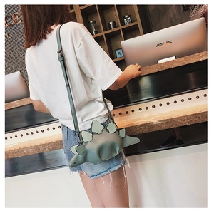 Detail view of the green dinosaur crossbody bag with distinctive stegosaurus back plates