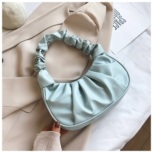 Close-up of light blue pleated dumpling bag showing soft cloud design and handle detail