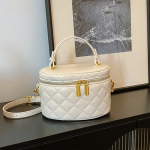 Elegant white quilted bucket handbag with golden hardware and adjustable strap