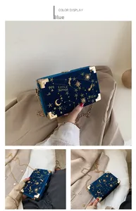 Détail du sac boîte en velours bleu avec broderie d'étoiles dorées et chaîne en métal