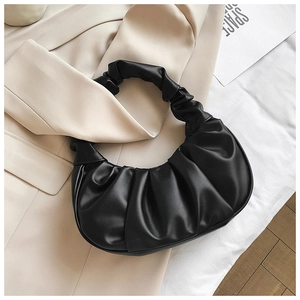 Close-up of black ruched dumpling bag showing detailed soft faux leather pleated texture