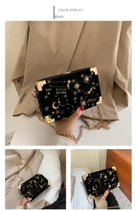 Détail du sac boîte en velours noir avec broderies d'étoiles dorées et motifs lune