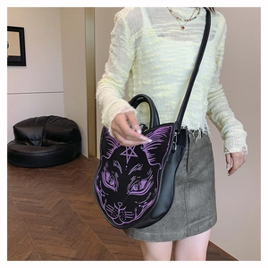 Detail of gothic cat face handbag with purple stitching and pentagram on black leather