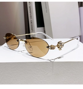 Detailed view of rhinestone flower hinge on frameless oval sunglasses with gold metal stems