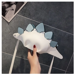 Detailed view of dinosaur shaped white PU leather crossbody bag with blue scales