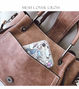 Detail of vintage brown matte leather bag with white stitching and metal cylinder handle