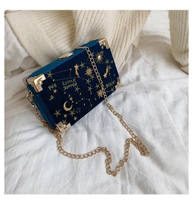 Détail du sac boîte en velours bleu marine avec broderie d'étoiles et chaîne dorée