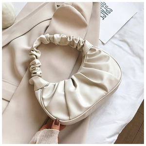 Close-up of cream white pleated dumpling bag with soft PU leather handle texture
