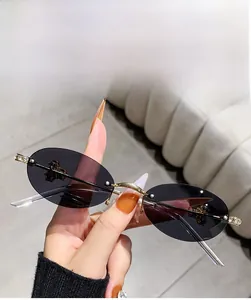 Close-up of rimless oval sunglasses with bright golden rhinestone-encrusted metal hinges