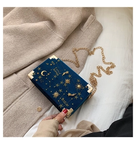 Broderie détaillée de lune dorée sur une pochette rigide en velours bleu marine