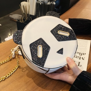 Cute panda shaped round crossbody bag with black sequins and gold chain strap held by hand