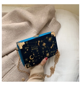 Détail du sac boîte en velours bleu avec broderie d'étoiles dorées et chaîne
