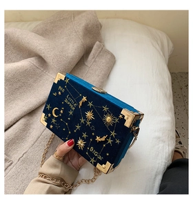 Vue détaillée du mini sac en velours bleu avec broderies célestes et chaîne dorée