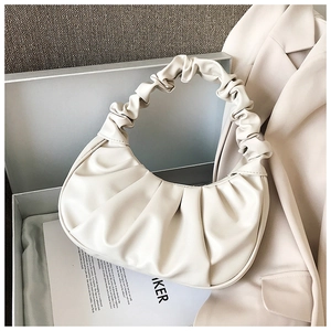 Detail of cream pleated cloud bag with scrunchie handle in a gift box arrangement