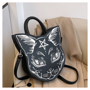 Detail of gothic cat face handbag with star print and metal strap buckles on a beige coat