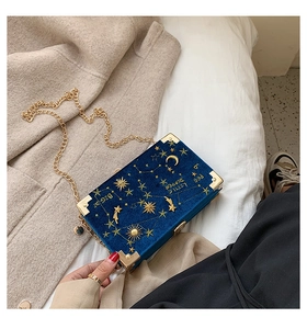 Détail du sac boîte en velours bleu avec broderies célestes dorées et chaîne en métal