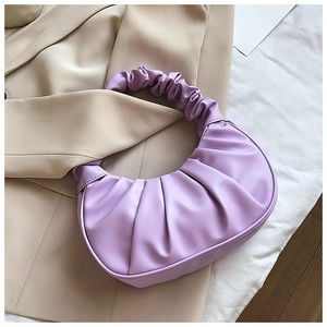 Detailed texture of lavender purple ruched hobo bag on a beige blazer fabric
