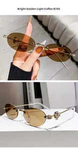 Close-up of rimless oval sunglasses with diamond-studded flower hinges and brown lenses