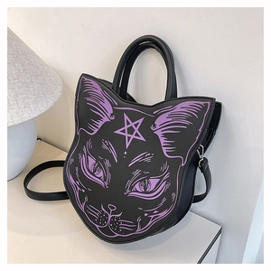 Detail of black cat-shaped handbag with purple gothic facial pattern and top handle