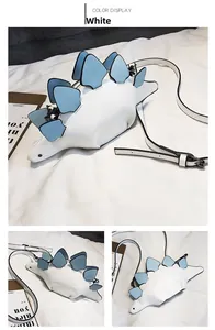 Detail view of a white PU leather dinosaur crossbody bag with blue dorsal plates on a rug