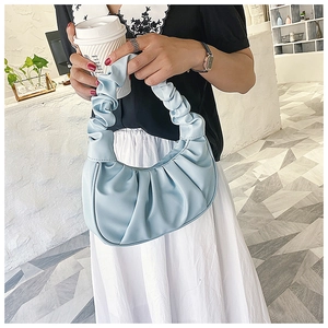 Close-up of a light blue ruched dumpling bag with detailed pleated faux leather texture