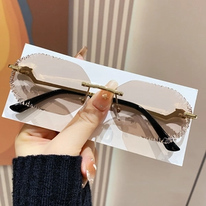 Frameless serrated sunglasses with gold metal leopard head detail and brown lenses
