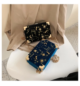 Détail de sacs boîtes en velours avec broderie étoilée et chaînes dorées en noir et bleu