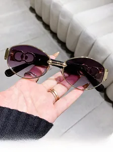Detail of vintage oval sunglasses featuring hollow decorative temples and gradient lenses