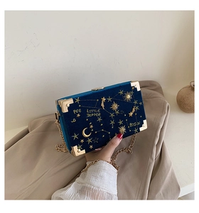 Détail du sac boîte en velours avec broderie d'étoiles dorées et chaîne en métal